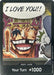 A trading card featuring a wide-eyed, grinning character with missing teeth and an eyepatch. The speech bubble above them says "I LOVE YOU!!" with Japanese characters. Labeled "DON!! Card (Special DON!! Card Pack) (Color) [Kingdoms of Intrigue]" at the bottom, this Kingdoms of Intrigue card reads "Your Turn +1000." This special edition card is produced by Bandai.