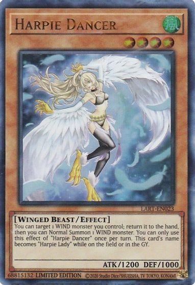 Image features a "Yu-Gi-Oh!" trading card titled "Harpie Dancer [LART-EN023] Ultra Rare," an Effect Monster. It depicts a female figure with blonde hair, wearing revealing armor with gold accents, and large white wings set against a blue sky background. The card's details include ATK/1200 DEF/1000 and a special effect description.