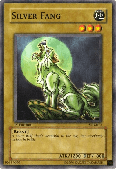 A Yu-Gi-Oh! trading card titled "Silver Fang [SDY-012] Common." It features an illustration of a green-tinged, wolf-like creature howling at the full moon in the background. This Common card is classified as a "Beast" Normal Monster with 1200 ATK and 800 DEF from the Starter Deck: Yugi. The caption reads, "A snow wolf that's beautiful to