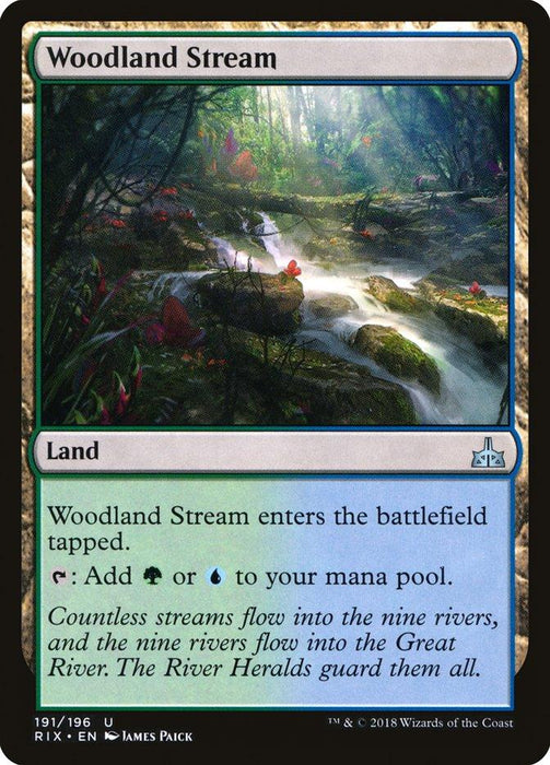 A Magic: The Gathering card named "Woodland Stream [Rivals of Ixalan]" from the Rivals of Ixalan set. It depicts a serene forest stream surrounded by lush greenery and brightly colored flowers. This Land card can add green or blue mana to your pool when tapped, with lore text at the bottom enhancing its mystical allure.