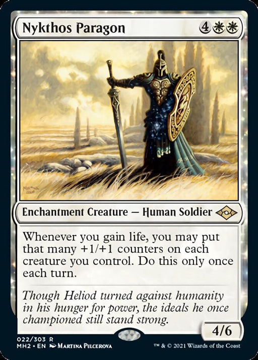 A **Magic: The Gathering** card titled "**Nykthos Paragon [Modern Horizons 2].**" As an Enchantment Creature from Modern Horizons 2, it costs 4 white mana and 2 colorless mana, with the text explaining its ability to add +1/+1 counters to other creatures when life is gained. It features a human soldier with a large winged helmet and shield in a desolate landscape.