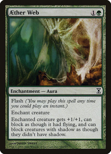 Magic: The Gathering's "Aether Web [Time Spiral]" card showcases mesmerizing green borders and a detailed tangled web design. This "Enchantment — Aura" boosts a creature's power with Reach, providing unique blocking abilities to surprise attackers.