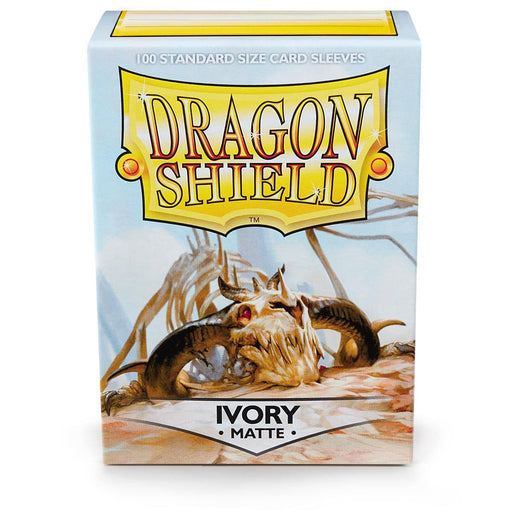 Image of an Arcane Tinmen brand box for Dragon Shield: Standard 100ct Sleeves - Ivory (Matte). The box features an illustration of a skull with large, curved horns set against a light blue backdrop. The text "Dragon Shield" is prominently displayed at the top, with "Ivory Matte" written at the bottom.