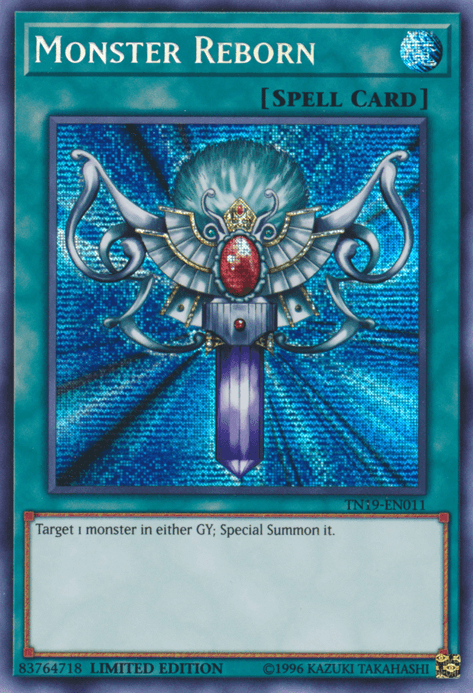 The image showcases the "Monster Reborn [TN19-EN011] Prismatic Secret Rare" Yu-Gi-Oh! spell card, a Prismatic Secret Rare from the Gold Sarcophagus Tin. It features an ornate silver ankh with blue gems and a large red central gem against a glittery blue background. Text at the bottom reads: "Target 1 monster in either GY; Special Summon it." Card ID: TN19