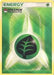 A Pokémon trading card titled "Grass Energy (2009 Unnumbered POP Promo) [League & Championship Cards]" with a distinct green, white, and yellow background. At the center is a circular icon featuring a dark green leaf on a black background, symbolizing Grass-type energy. The top left corner displays the Pokémon logo and the words "Organized Play: League & Championship Cards.