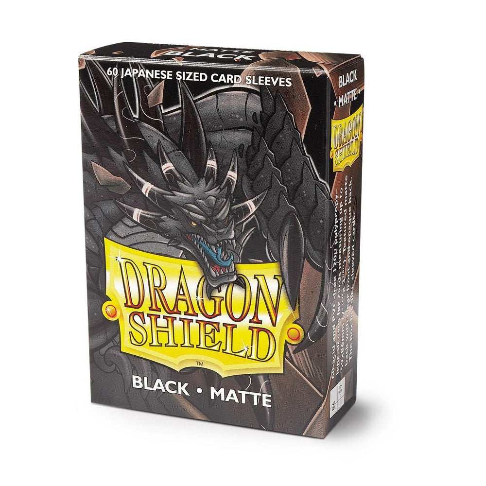 The image showcases a box of Arcane Tinmen Dragon Shield: Japanese Size 60ct Sleeves - Black (Matte) tailored for Japanese-sized cards, with the front prominently featuring a fierce, black dragon. The product name "Arcane Tinmen" is displayed in yellow text alongside specifications "Black" and "Matte." The box contains 60 Japanese size sleeves.