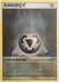 Close-up of a rare Pokémon card titled "Metal Energy (97/115) (Stamped) [EX: Unseen Forces]" from the Pokémon set. The card features a metallic symbol resembling three triangles forming a larger triangle. The bottom text details its effects, reducing damage by 10 for the Pokémon it is attached to. Illustrated by Milky Isobe.
