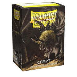 Arcane Tinmen's Dragon Shield: Standard 100ct Sleeves - Crypt (Dual Matte) feature an intricate fantasy artwork of a menacing dragon head with sharp teeth in a golden helmet on a dark, cavernous background. Contains 100 opaque sleeves with black interiors.