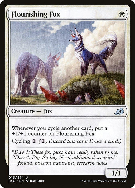 A Magic: The Gathering card titled Flourishing Fox [Ikoria: Lair of Behemoths]. It depicts a white fox standing alert with another fox in the background. The card features its cycling ability and flavor text about fox pups. Artist Ida Gort is credited at the bottom right, and its stats are 1/1.