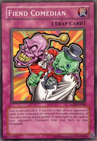 A Yu-Gi-Oh! trading card titled "Fiend Comedian [LOD-EN098] Common," classified as a Normal Trap. The card features an illustration of two clown characters, one pink and sinister-looking, the other green and cheerful, performing a juggling act. Part of the Legacy of Darkness series, its text describes a coin toss effect to remove or transfer cards from the graveyard.