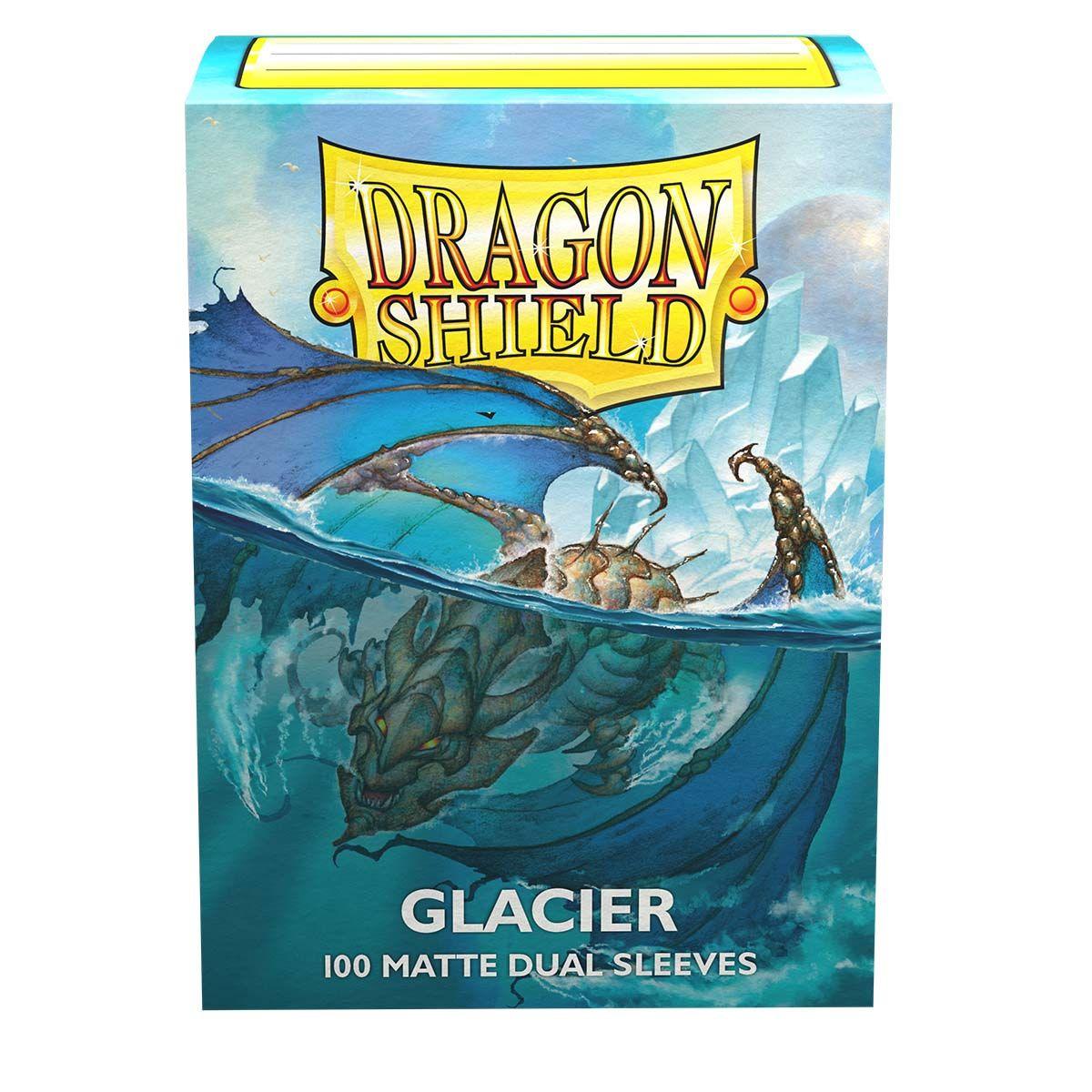 The image shows a sturdy cardboard box of Arcane Tinmen Dragon Shield: Standard 100ct Sleeves - Glacier (Dual Matte) featuring artwork of a fierce dragon emerging from icy water with glacier formations in the background. The box, labeled 