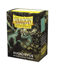 Dragon Shield: Standard 100ct Sleeves - Eucalyptus (Dual Matte) by Arcane Tinmen feature a green dragon in a forest, sleek design with glossy back, small image showing both sides. The predominantly green and yellow packaging carries an enchanting fantasy theme.