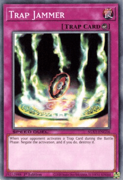 Image of a Yu-Gi-Oh! trading card titled "Trap Jammer [SGX1-ENG16] Common." It features an image of a circular saw blade breaking free from magical restraints, with green energy spiraling around it. This Counter Trap has magenta borders and text explaining its effect: "When your opponent activates a Trap Card during the Battle Phase: Negate the activation, and if you do, destroy it." Perfect.
