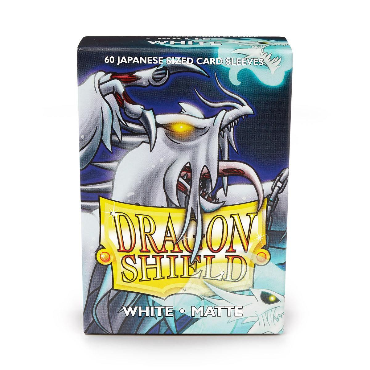 A box of Arcane Tinmen's Dragon Shield: Japanese Size 60ct Sleeves - White (Matte) is depicted with a white matte finish, specifically designed for Japanese-sized sleeves. The artwork showcases a menacing dragon with glowing yellow eyes. Text on the box reads 