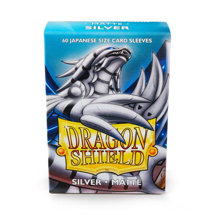 A box of Arcane Tinmen Dragon Shield: Japanese Size 60ct Sleeves - Silver (Matte) is shown. The packaging features an illustration of a silver dragon against a blue background. The text reads, "60 Japanese size card sleeves," and "Dragon Shield Silver Matte." Perfect for Japanese card games, the box holds matte-finish, silver-colored sleeves for trading cards.