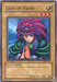 Image of the "Lady of Faith [MRD-119] Common" Yu-Gi-Oh! trading card from the Metal Raiders set. This common Normal Monster features a woman in a striped purple and red headdress, green clothing, and a serene expression with her hands in a praying gesture. The card has an ATK of 1100 and DEF of 800 and is categorized as a Spellcaster.