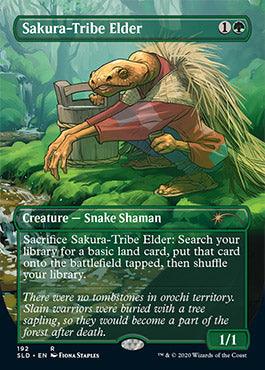 A fantasy card from Magic: The Gathering, Sakura-Tribe Elder (Borderless) [Secret Lair Drop Series], features "Sakura-Tribe Elder," a green, snake-like shaman creature holding a walking stick. This Creature — Snake Shaman can sacrifice itself to search for a basic land card to place tapped onto the battlefield. It has 1/1 power/toughness and detailed artwork by Fiona Staples.