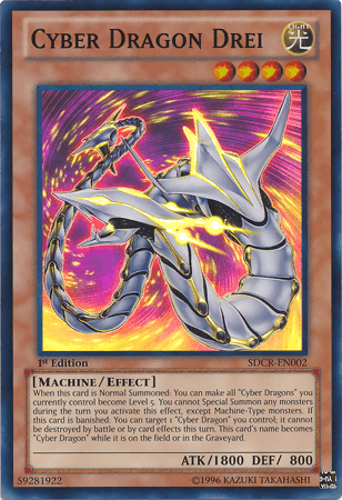 Image of a Yu-Gi-Oh! trading card titled "Cyber Dragon Drei [SDCR-EN002] Super Rare." The card features an illustration of a sleek, mechanical dragon with segmented armor and a glowing core. The dragon's design includes sharp, metallic edges and a streamlined body, colored in silver and accented with yellow lights. The 1st Edition Effect Monster has attributes: Machine/Effect, ATK 1800.
