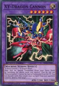 A Yu-Gi-Oh! product titled "XY-Dragon Cannon [SBCB-EN083] Common" from the Battle City Box. The card features an illustration of a mechanized dragon composed of blue and red armor with cannons mounted on its wings. The card has 2200 attack points and 1900 defense points. It is a Machine/Fusion/Effect monster card.
