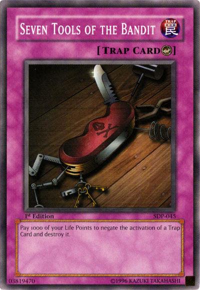 The image shows the Yu-Gi-Oh! Counter Trap card "Seven Tools of the Bandit [SDP-045] Common" with a purple border. The artwork depicts various tools on a wooden table, including a key, scissors, and a coiled spring. The card description reads: “Pay 1000 of your Life Points to negate the activation of a Trap Card and destroy it.”