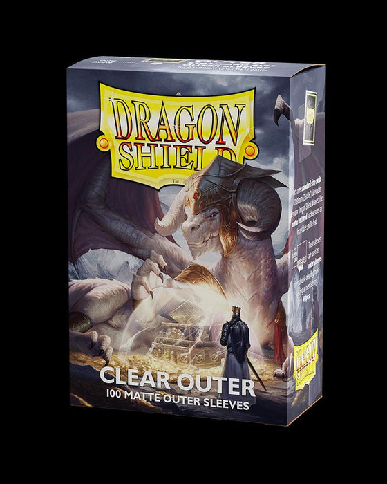 A box of Arcane Tinmen Dragon Shield: 100ct Outer Sleeves - Clear Matte (Standard) featuring an illustration of a white dragon with horns guarding a treasure chest. A small, armored figure stands in the foreground. The box contains 100 card sleeves for optimal card protection and has text detailing product features on the side.
