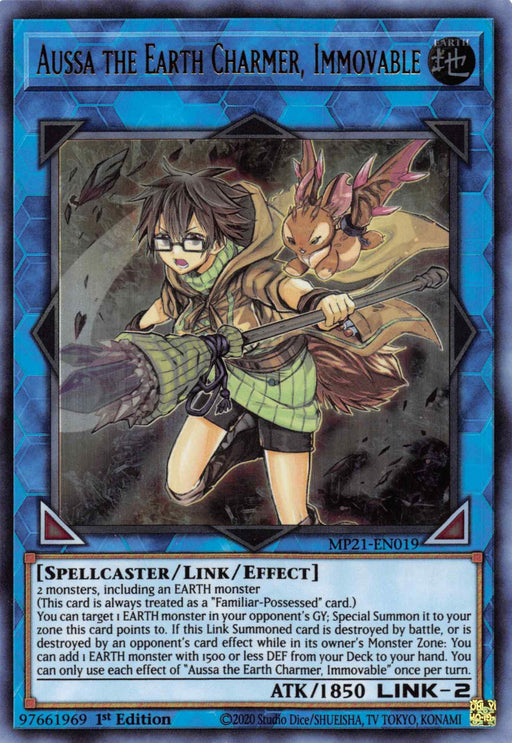 An Ultra Rare Yu-Gi-Oh! trading card featuring "Aussa the Earth Charmer, Immovable [MP21-EN019] Ultra Rare". The card displays a spellcaster character with glasses, in green attire, wielding a staff, and accompanied by a small brown creature. It has 1850 ATK, 2 LINK, and contains detailed effect text including summoning conditions and gameplay abilities.