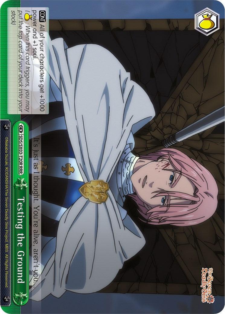 Image of a trading card featuring an anime character with pink hair and a white cloak. The character has a serious expression and is tied with ropes against a wooden structure. The card, titled 