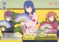 An anime-style image features three characters, two females and one male, each dressed in traditional Japanese attire. They hold ornate fans and appear to be participating in a dance reminiscent of Revue Starlight. Text bubbles have dialogue, with various symbols and text descriptions typical of a Trial Deck card layout for the product Actor Training Department Lesson (RSL/S56-TE07 TD) [Revue Starlight] by Bushiroad.