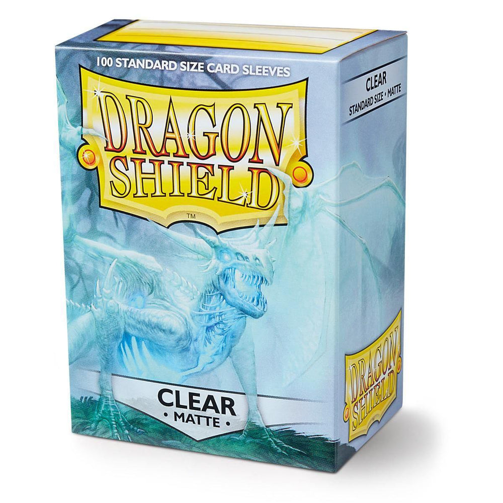 A box of durable Arcane Tinmen Dragon Shield: Standard 100ct Sleeves - Clear (Matte) card sleeves is pictured. The packaging is predominantly blue, featuring the brand's logo with a dragon illustration. "100 Standard Size Card Sleeves" is printed at the top, and "Clear Matte" is prominently displayed at the bottom.