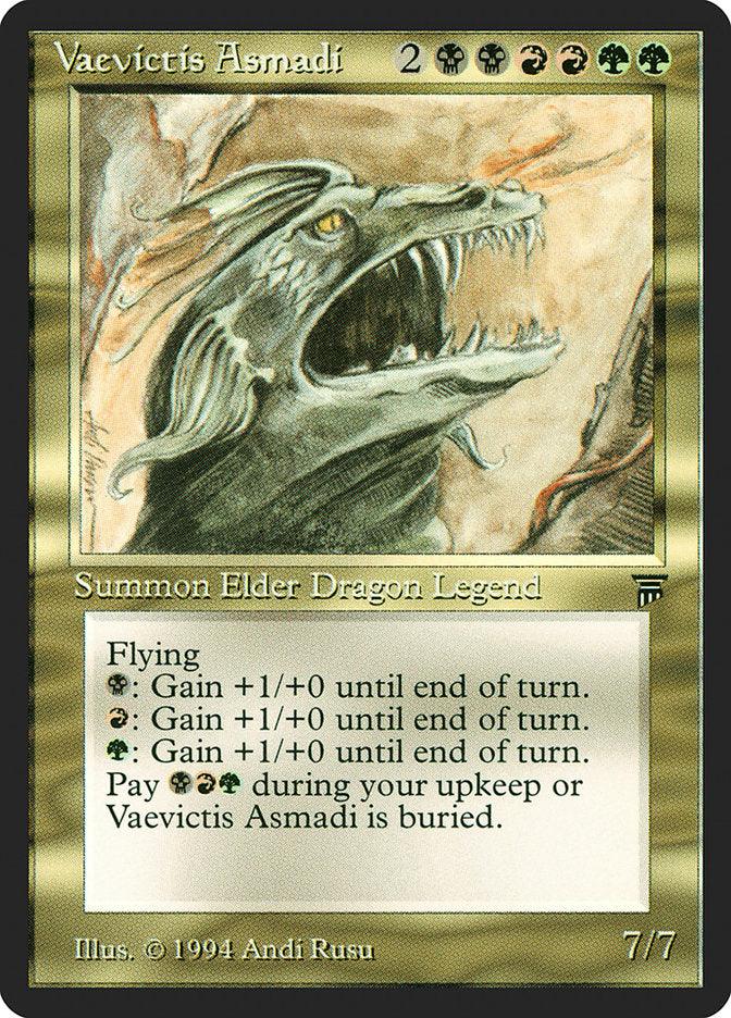 A detailed image of the "Vaevictis Asmadi [Legends]" Magic: The Gathering card. This Elder Dragon is depicted with its mouth open, showcasing its fierce nature. The Legendary Creature's text includes its flying ability and mana-cost activations to boost power. Artist credit reads "Illus. © 1994 Andi Rusu." Power and toughness are 7/7.