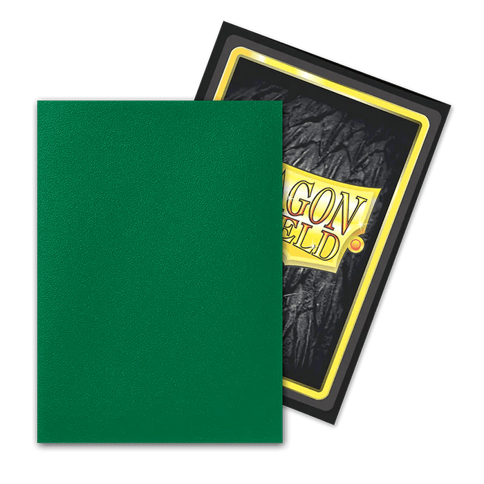 Displayed are two trading cards. The front card features a simple green surface, while the back card stands out with a textured black background adorned with bold "Dragon Shield" lettering and striking yellow-red accents. Overlapping slightly, they elegantly reveal both designs, reminiscent of the sleek style offered by Arcane Tinmen's Dragon Shield: Standard 100ct Sleeves - Might (Dual Matte).