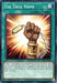 The image depicts "The True Name [EGS1-EN030] Common" Spell Card from the Yu-Gi-Oh! trading card game. The illustration shows a clenched fist holding a necklace with a luminous golden pendant, surrounded by radiant light against a blue background. This card is essential for any fan of the Egyptian God Decks, especially Slifer the Sky Dragon.