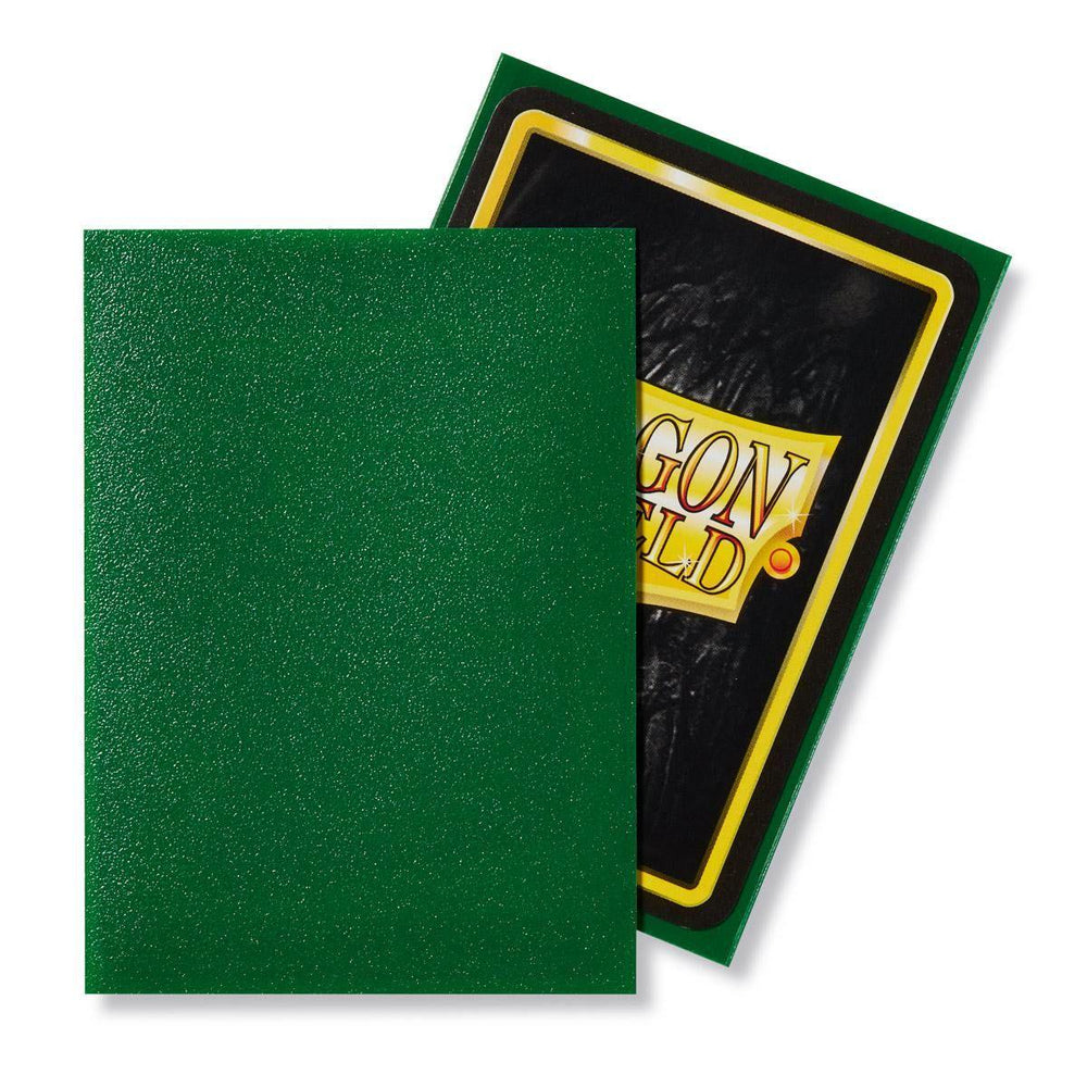 The image features Dragon Shield: Standard 100ct Sleeves - Emerald (Matte) by Arcane Tinmen. The front sleeve is solid green with a textured matte finish, while the back has a green border and a yellow rectangle displaying "Dragon Shield" in stylized text on a black background.