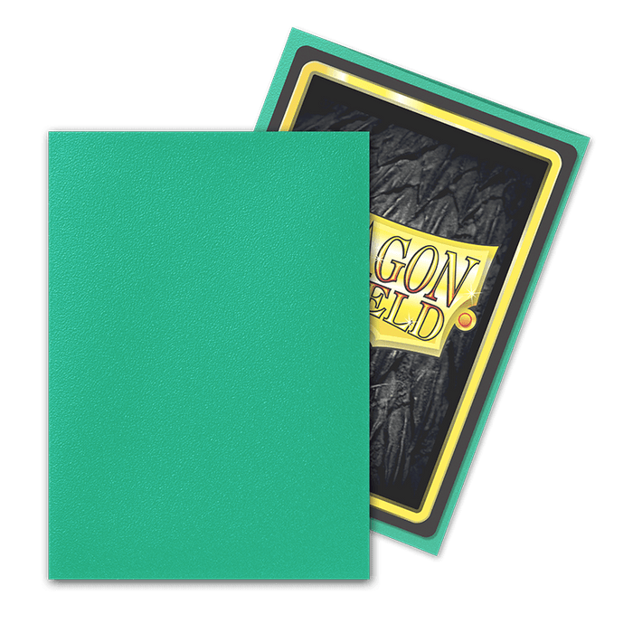 A TCG card sleeve reveals a trading card partly out of its plain green cover. The visible portion of the card's back showcases a black textured design with a prominent yellow "DRAGON SHIELD" emblem. This Arcane Tinmen Dragon Shield: Standard 100ct Sleeves - Aurora (Matte) ensures your valuable cards are both protected and stylishly displayed.