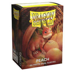 A box of Dragon Shield: Standard 100ct Sleeves - Peach (Dual Matte) by Arcane Tinmen. The sturdy cardboard packaging features a detailed illustration of a small, playful dragon with peach-like texture and colors, sitting amid peaches. The box contains 100 matte dual sleeves with a black interior. The logo "Dragon Shield" is prominently displayed at the top.