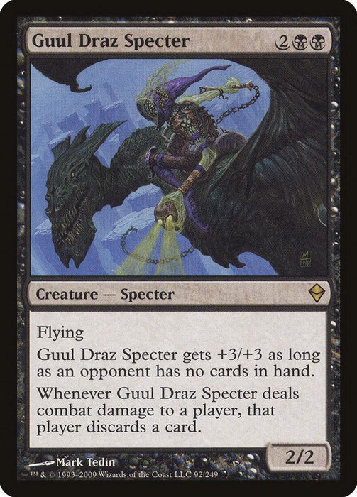 A "Magic: The Gathering" card titled "Guul Draz Specter [Zendikar]." Costing 2 black and 2 colorless mana, this rare Specter creature from Zendikar has flying with base power/toughness of 2/2. It gains +3/+3 if an opponent has no cards, and forces them to discard a card when it deals combat damage. Art depicts a