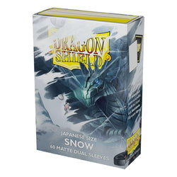 The image depicts a box of Dragon Shield: Japanese Size 60ct Sleeves - Snow (Dual Matte), featuring a "Snow" theme. The artwork showcases a fierce, icy dragon amidst a snowy landscape. The box contains 60 fully opaque sleeves, with Arcane Tinmen's logo and other product details prominently displayed.