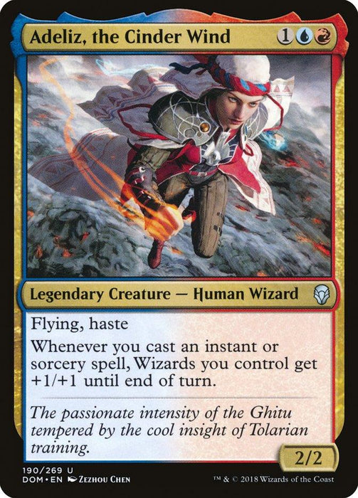 Adeliz, the Cinder Wind [Dominaria] card from Magic: The Gathering displays a human wizard in mid-air, casting a spell with a trail of flames. This legendary creature from Dominaria, adorned with blue and red borders, details attributes including flying, haste, and a bonus for instants and sorceries.