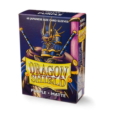 Image of a box of Dragon Shield: Japanese Size 60ct Sleeves - Purple (Matte) by Arcane Tinmen. The box features artwork of an armored dragon wielding two swords, with text reading "Dragon Shield, Purple, Matte" and "60 Japanese Size Card Sleeves." The packaging is primarily purple with yellow and white text accents.