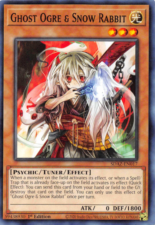 Yu-Gi-Oh! trading card titled “Ghost Ogre & Snow Rabbit [SDAZ-EN017] Common.” This Tuner/Effect Monster features an anime-style white-haired female character with red eyes, holding a staff. She wears a dark outfit with red accents and stands in a magical aura. The card’s text box, part of the Structure Deck: Albaz Strike, details its abilities and attributes.
