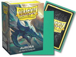 A box of Arcane Tinmen Dragon Shield: Standard 100ct Sleeves - Aurora (Matte), displaying a dragon with aurora-like colors, is shown. Next to the box, a sleeve faces forward, showing the Dragon Shield logo, while another sleeve, green on the back, lies partially in front. Text on the box reads "100 MATTE SLEEVES.