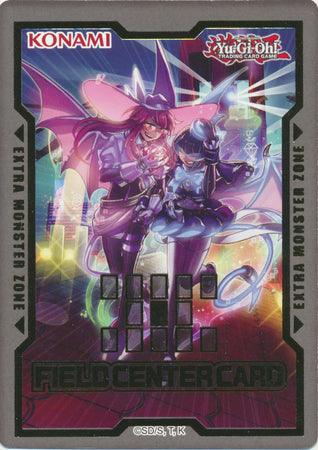 Yu-Gi-Oh! trading card labeled "Field Center Card: Evil Twin (Back to Duel February 2022) Promo" at the bottom. This promotional card features dynamic, colorful artwork of two fantasy characters in dramatic poses, surrounded by neon lights and vibrant energy bursts. The background includes text zones and branding elements from Konami and Yu-Gi-Oh! in the corners. Perfect for tournaments!